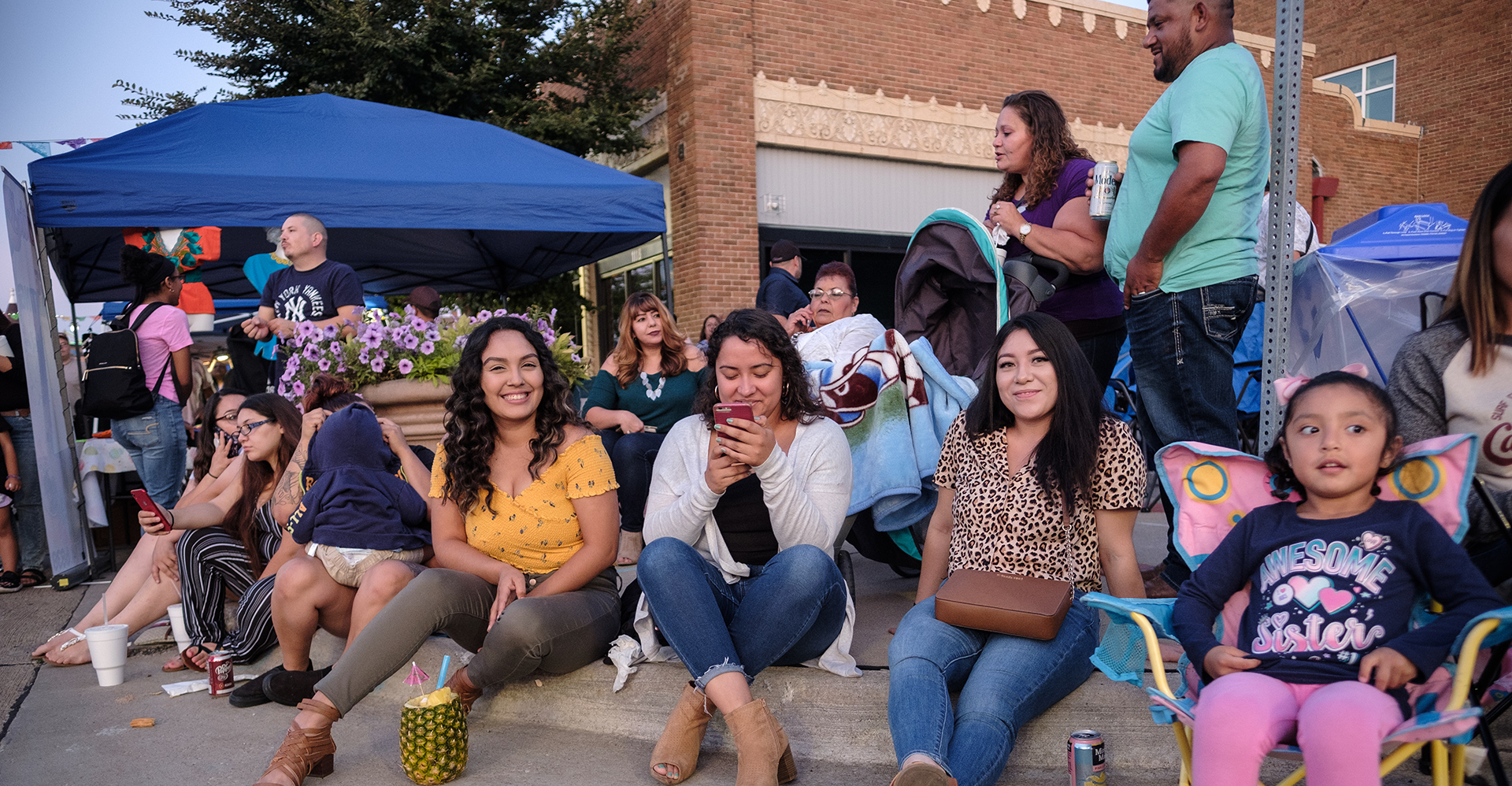 people smilling and sitting during Mercado on Fifth in downtown Moline Quad City.