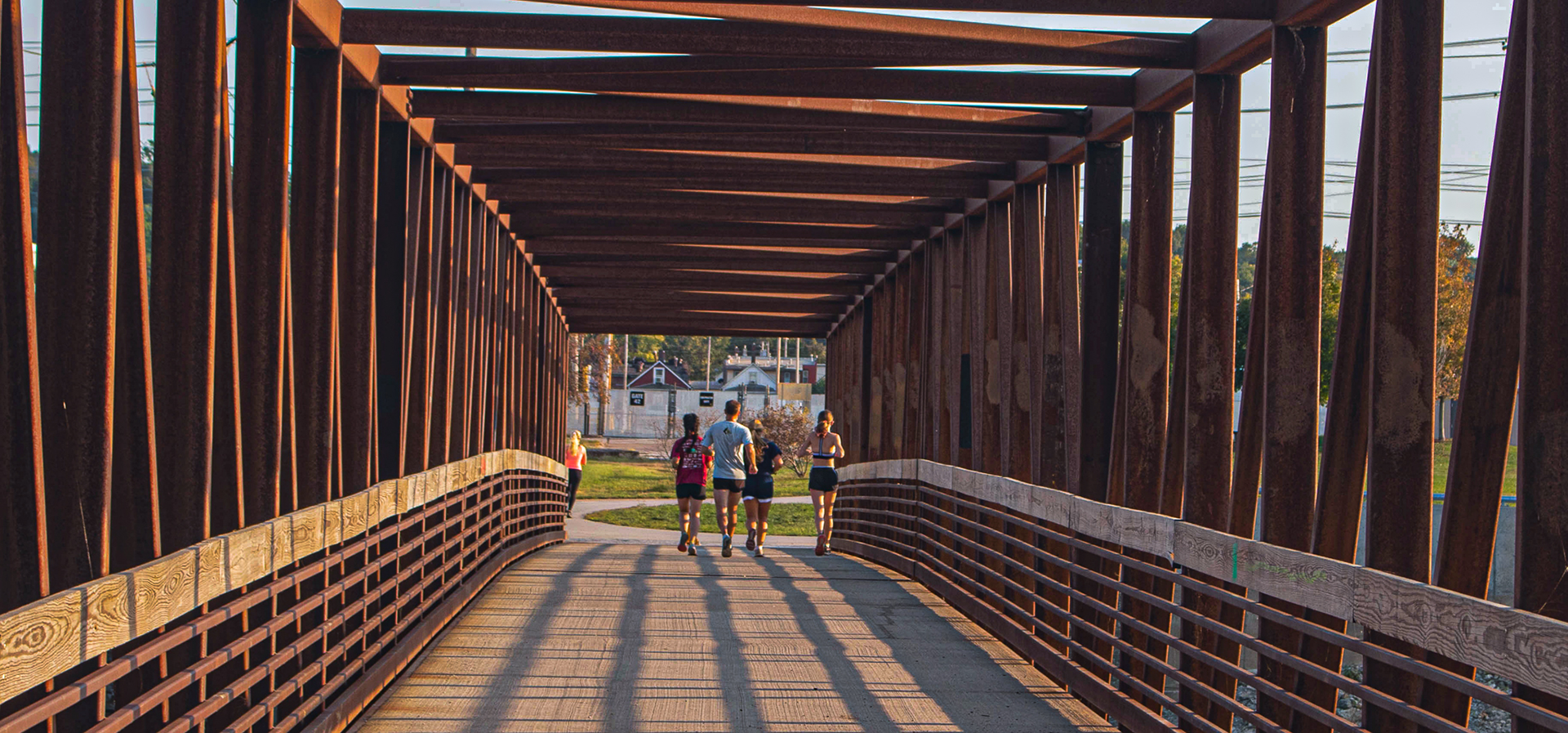 high school students running through the bridge connecting to the Sylvan Island QC.
