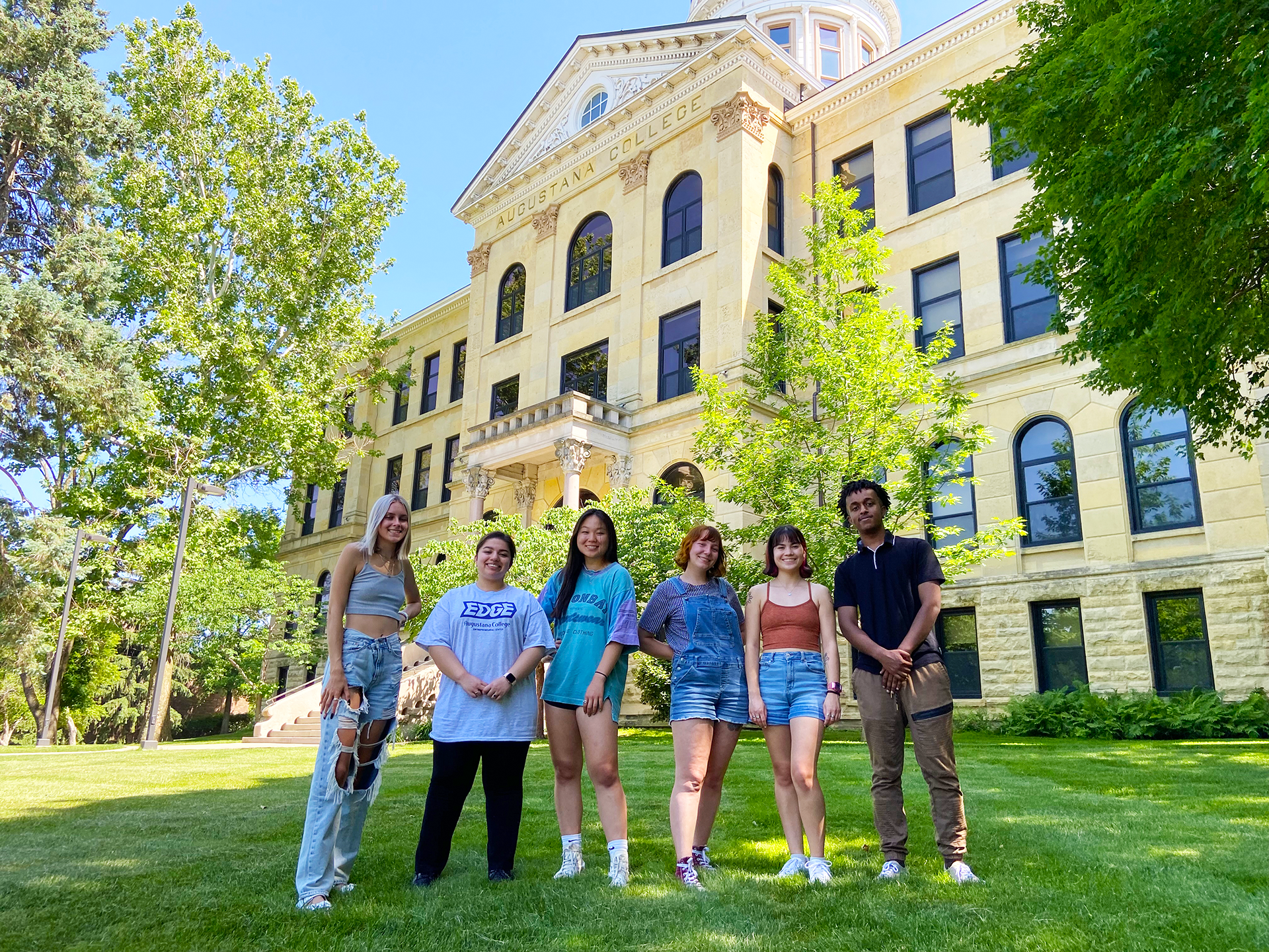 Cool QC's members walking and smiling at the camera in downtown Moline.